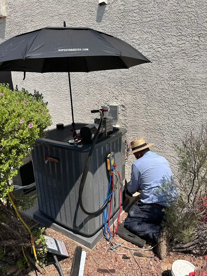 HVAC technician performing outdoor AC maintenance in Alabaster