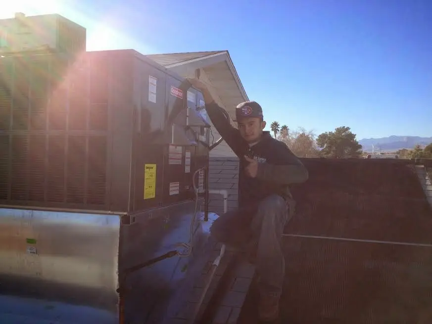 HVAC technician performing Heat Pump Repair on a rooftop unit in Alabaster